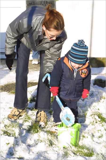 Rachel shows Kyle how to shovel up the snow