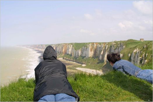Trish on left, Imelda on right safely peeking over the edge at the Normandy cliffs in a gale force wind!