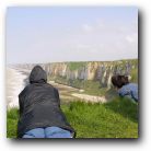 Trish on left, Imelda on right safely peeking over the edge at the Normandy cliffs in a gale force wind!