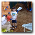Mom demonstrates how to go down the slide 