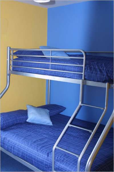 Single on top with double on bottom aluminium-look bunk bed with royal blue bed linen 