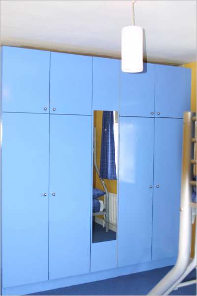 Aluminium handles against Achill blue paint - what a transformation. See reflection of curtains in wardrobe mirror. The curtains match the bed linen. We also added a dimmer switch to the ceiling light with a neutral drop shade to match the window blind. 