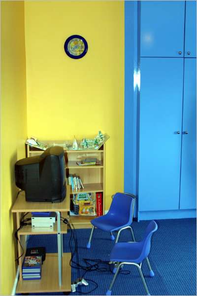 Matching blue chairs watched over by Bob the Builder clock that tells the boys how long they can play their computer games